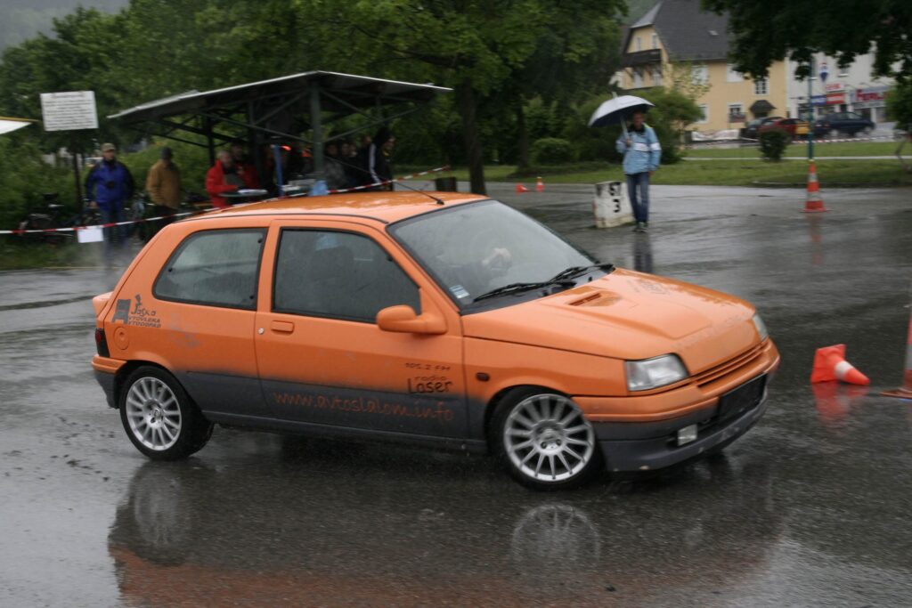 Orange Renault Clio MK1 at a wet autoslalom